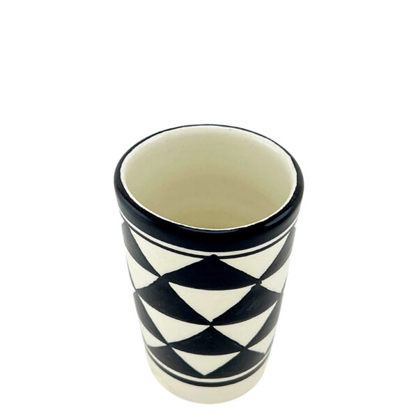 Gobelet artisanal en porcelaine de Fès, motifs géométriques noirs et blancs, peint à la main, idéal pour boissons ou décoration, personnalisable.